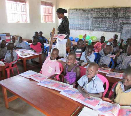 Agwata School kindergartners reading their new book, How the Zebra Lost Its Stripes, provided by Outreach Uganda.  – July 2017